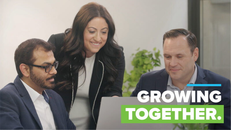 3 professionals collaborating around laptop