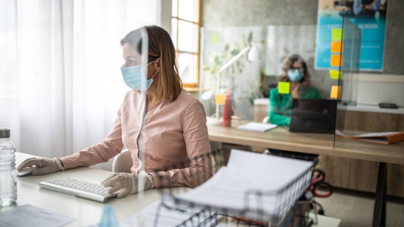 Woman wearing a mask and working in an office