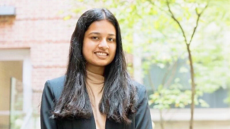 Young woman smiling outdoors, representing diversity in insurance industry.